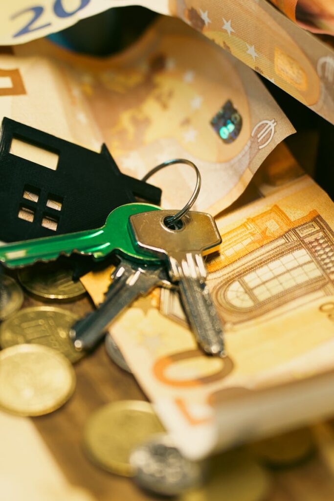 Euro currency with house keys and miniature models, symbolizing real estate investment.