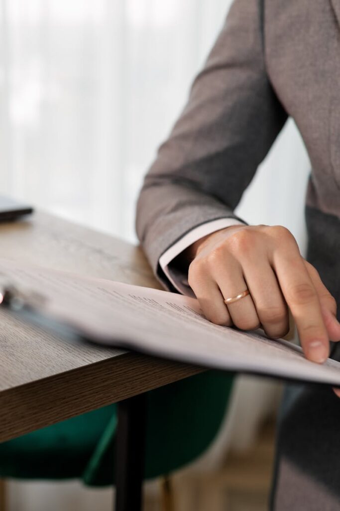 Professional businessman in suit reviewing documents on clipboard at office desk.