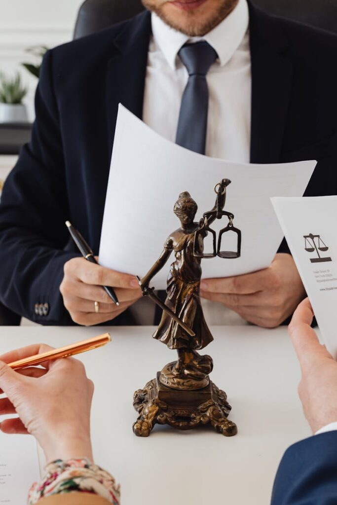 Legal professionals reviewing divorce documents in a law office with a Lady Justice statue.